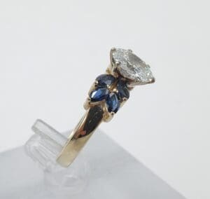Gold ring with diamond and blue gemstones.