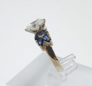 Gold ring with diamond and blue stones.