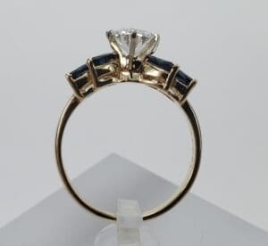 Gold ring with diamond and dark stones.