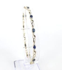 Gold bracelet with blue gemstones display.