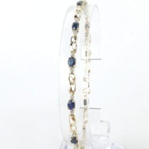 Gold bracelet with blue gemstones display.