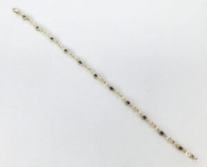 Gold chain bracelet with black accents.