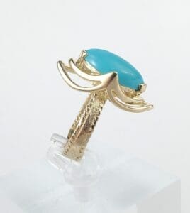 Gold ring with turquoise stone setting.