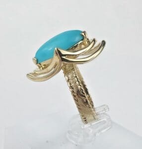 Gold ring with turquoise stone setting.