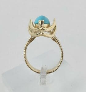 Gold ring with blue stone setting.