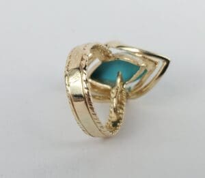 Gold ring with turquoise gemstone setting.