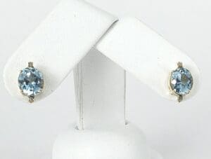 Blue gemstone earrings on white display stand.