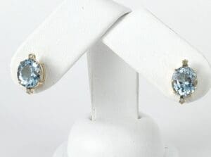 Aquamarine gemstone earrings on display stand.