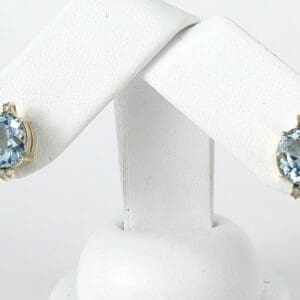 Aquamarine gemstone earrings on display stand.