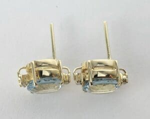 Gold earrings with light blue gemstones.