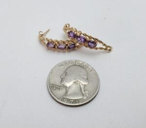 Gold earrings with purple stones, quarter coin.