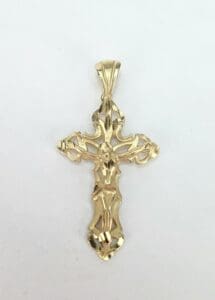 Ornate gold crucifix pendant on white background.