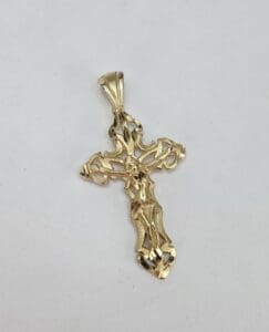 Gold crucifix pendant on white background.