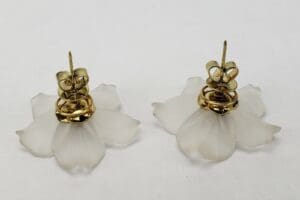 Gold and white flower-shaped earrings.