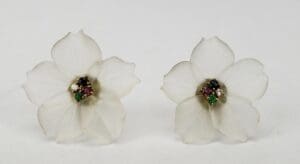 White flower earrings with colorful gemstone centers.