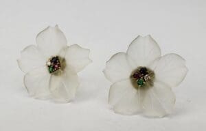 White flower earrings with colorful gemstone centers.