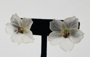 White flower earrings with colorful gem centers.