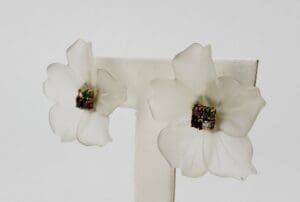 White flower earrings with colorful centers.