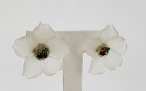 White flower earrings with colorful gem centers.