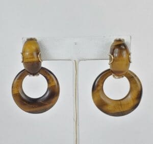 Brown hoop earrings on display stand.
