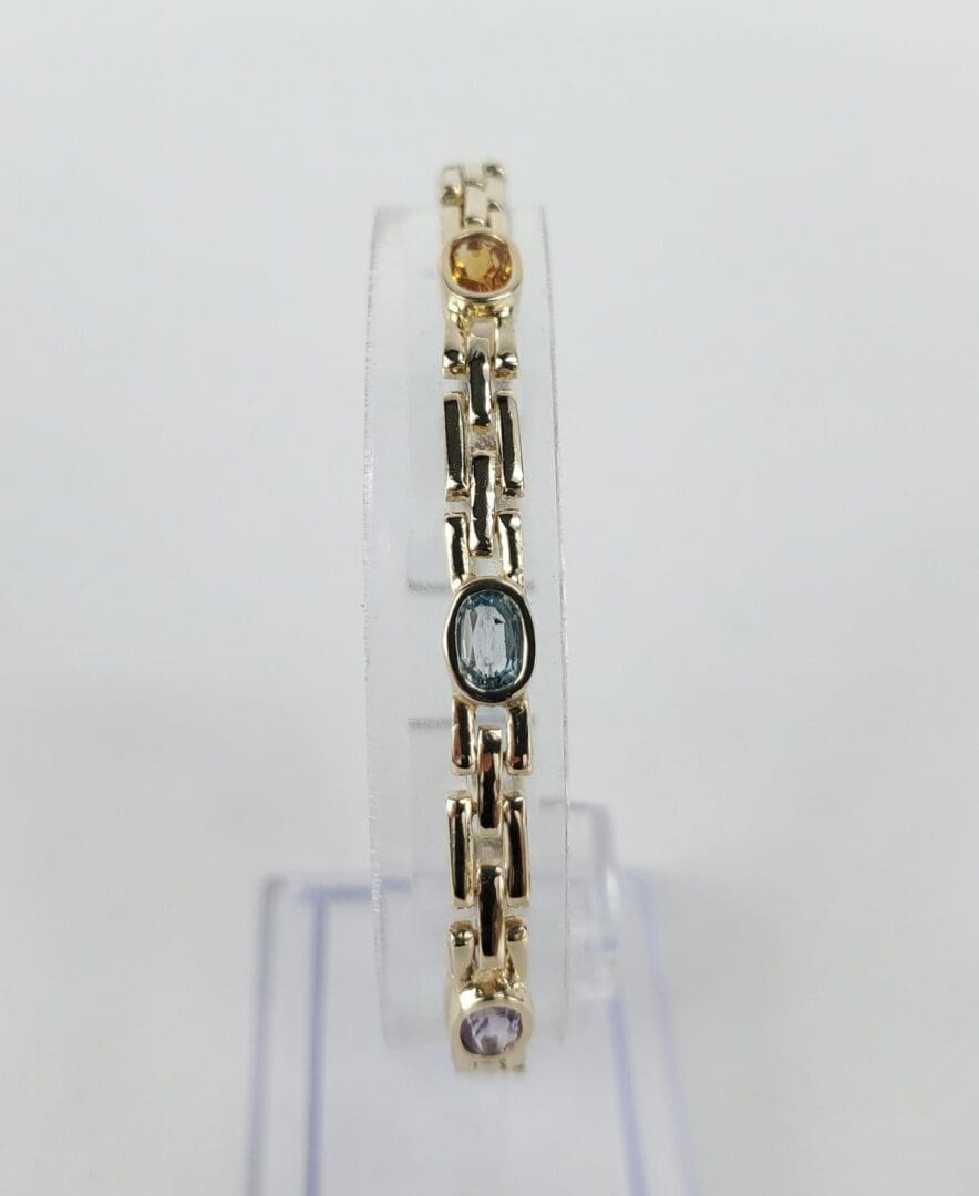 Gold bracelet with colorful gemstones.
