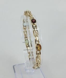 Gold bracelet with colorful gemstone accents.