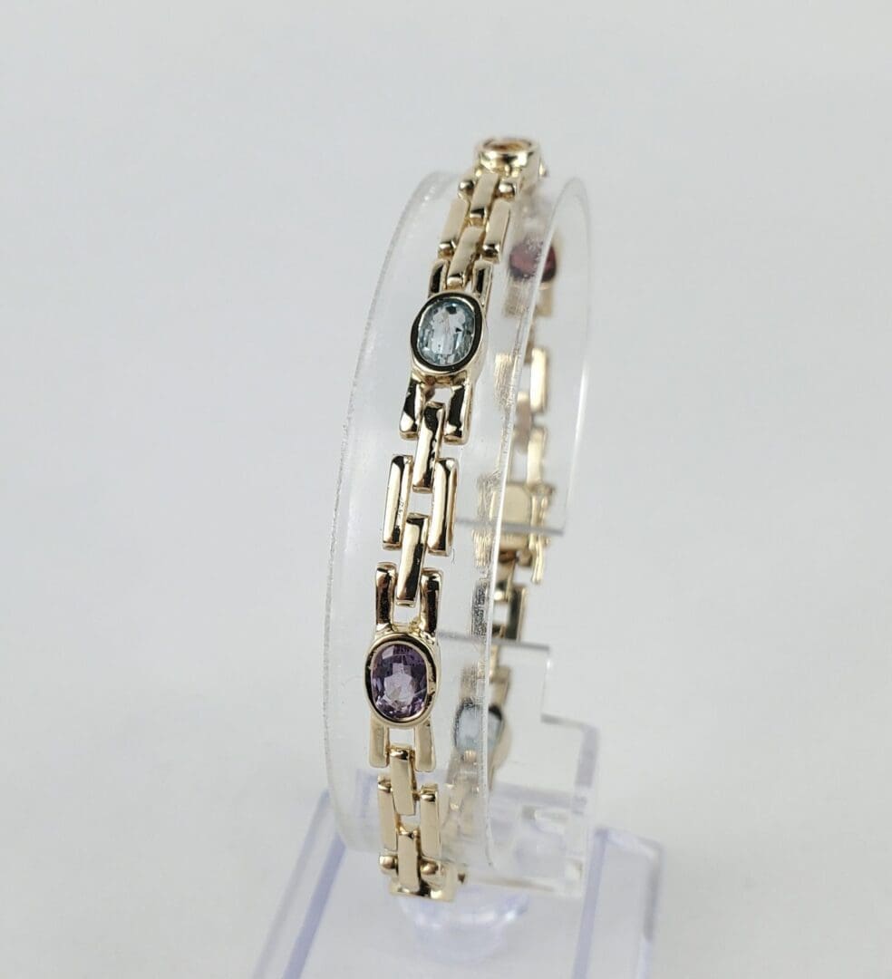 Gold bracelet with colorful gemstone accents.