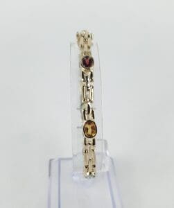 Gold bracelet with red and yellow stones.