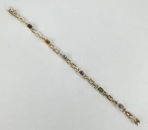 Gold bracelet with colorful gemstone links.