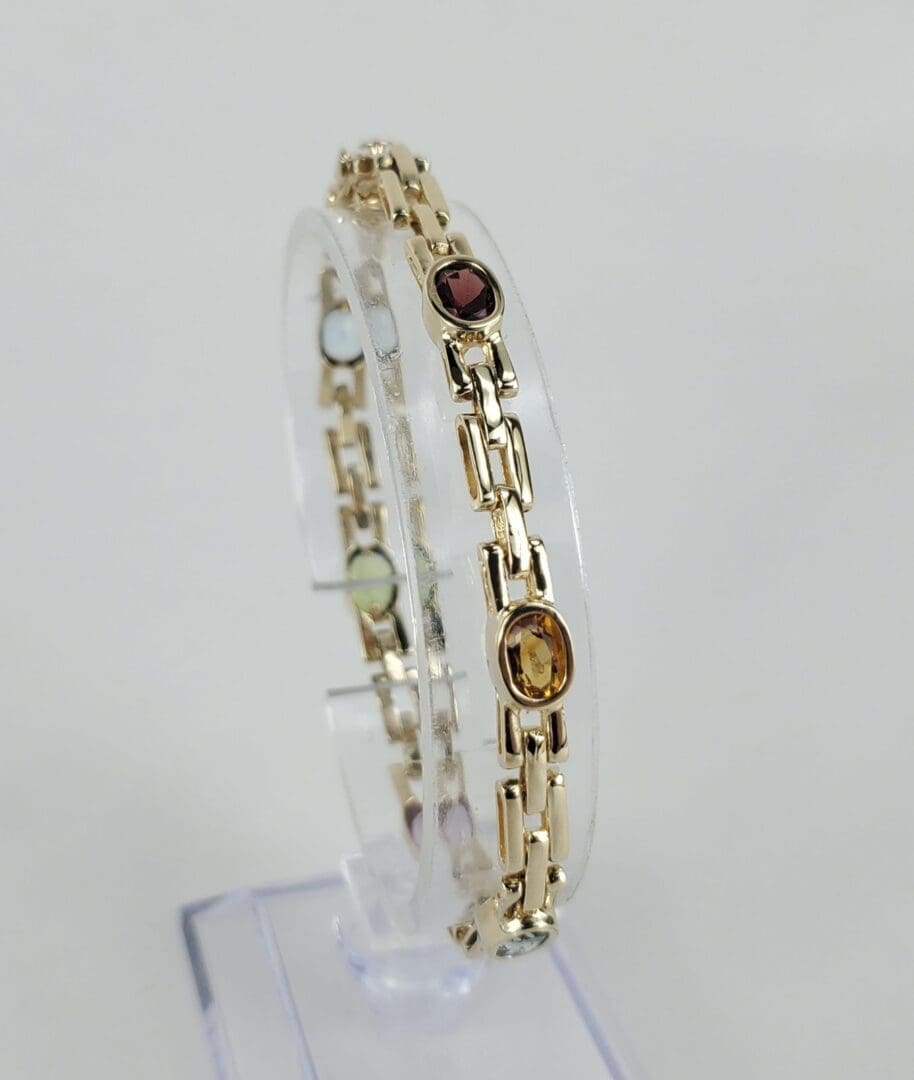 Gold bracelet with colorful gemstone accents.