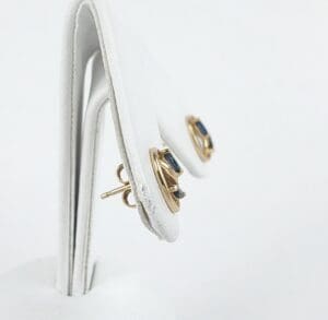 Gold earrings with blue stones on display.