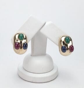 Gold earrings with colorful gemstones displayed elegantly.