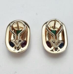 Gold earrings with colorful gem accents.