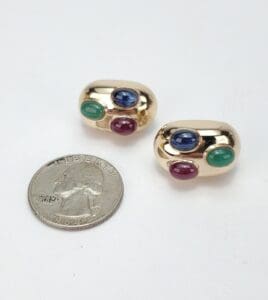 Gold earrings with colorful gemstones and coin.