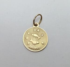 Gold Pisces zodiac pendant with fish design.