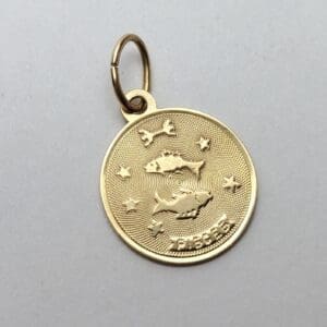 Gold Pisces pendant with fish design.