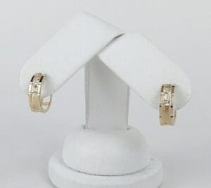 Gold earrings with diamond accents on display.