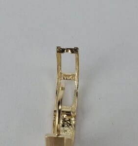 Gold earring with rectangular design detail.