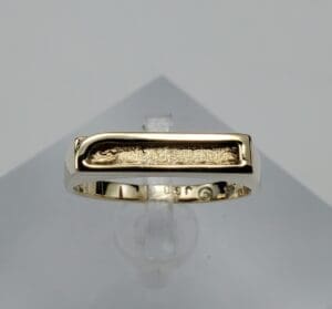 Gold ring with a textured rectangular design.