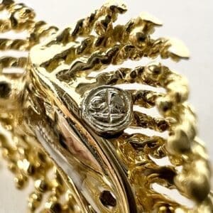 Gold ornate jewelry with central silver emblem.