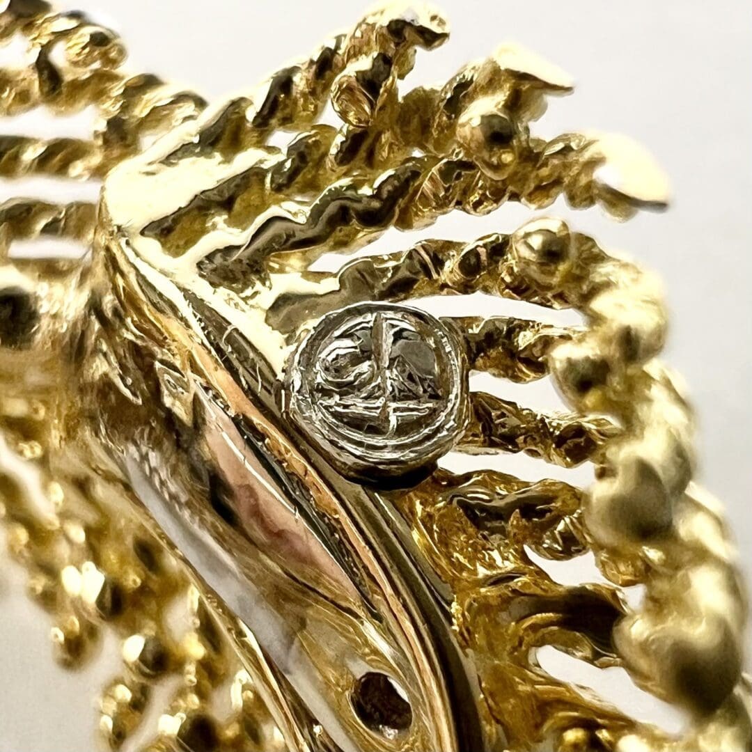 Gold ornate jewelry with central silver emblem.