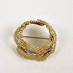 Gold and silver decorative brooch on display.