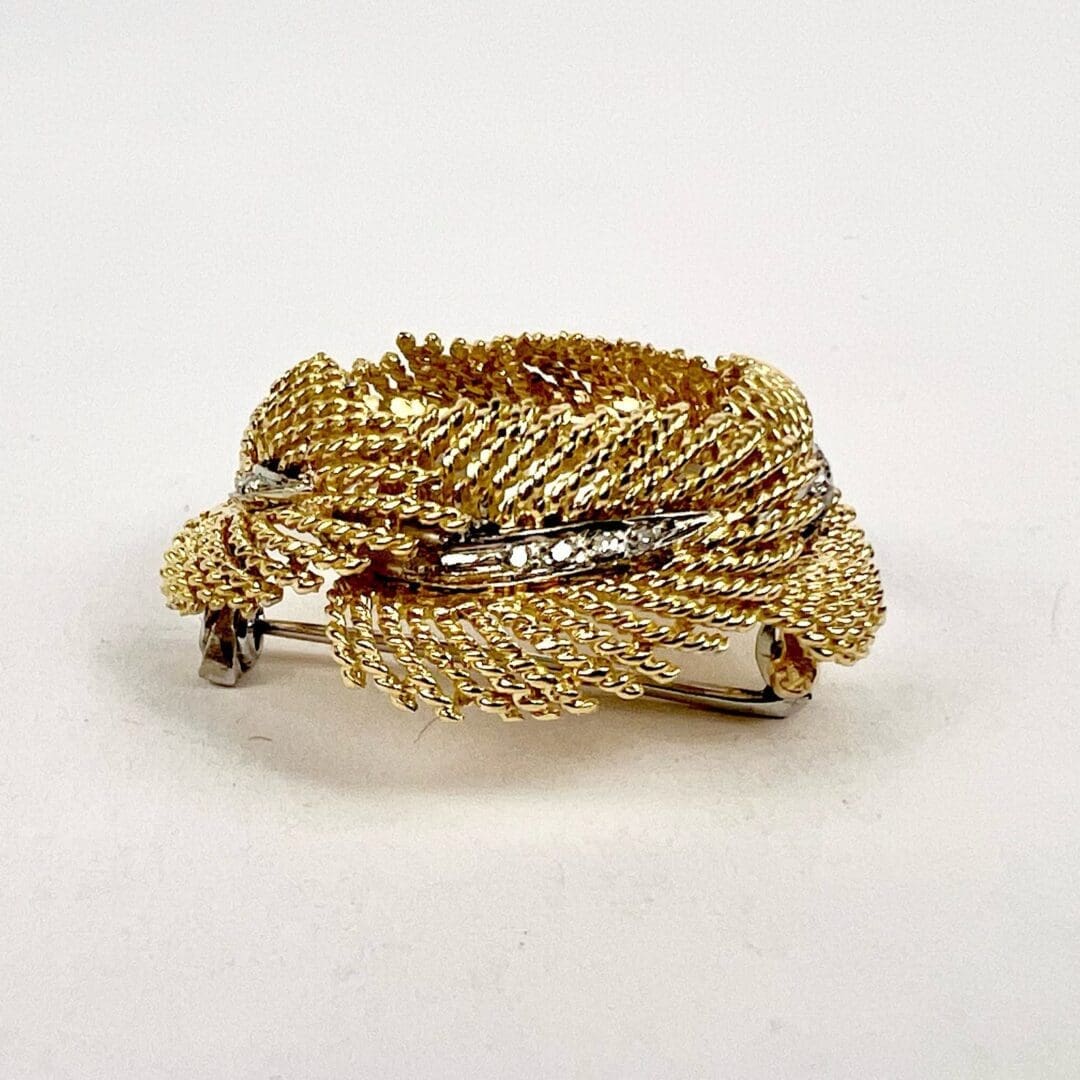 Gold twisted rope brooch with diamonds.