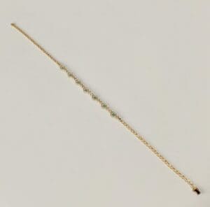 Gold bracelet with green gemstone accents.