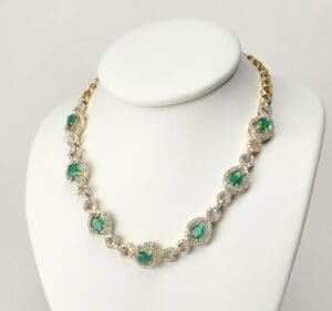 Gold necklace with emerald and diamond accents.