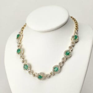 Gold necklace with emerald and diamond accents.