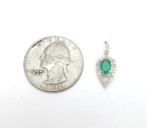 Quarter coin next to emerald pendant.