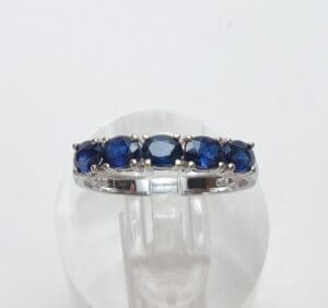 Silver ring with blue gemstones on display.