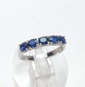 Silver ring with blue gemstones on display.