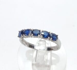 Silver ring with blue gemstones on display.